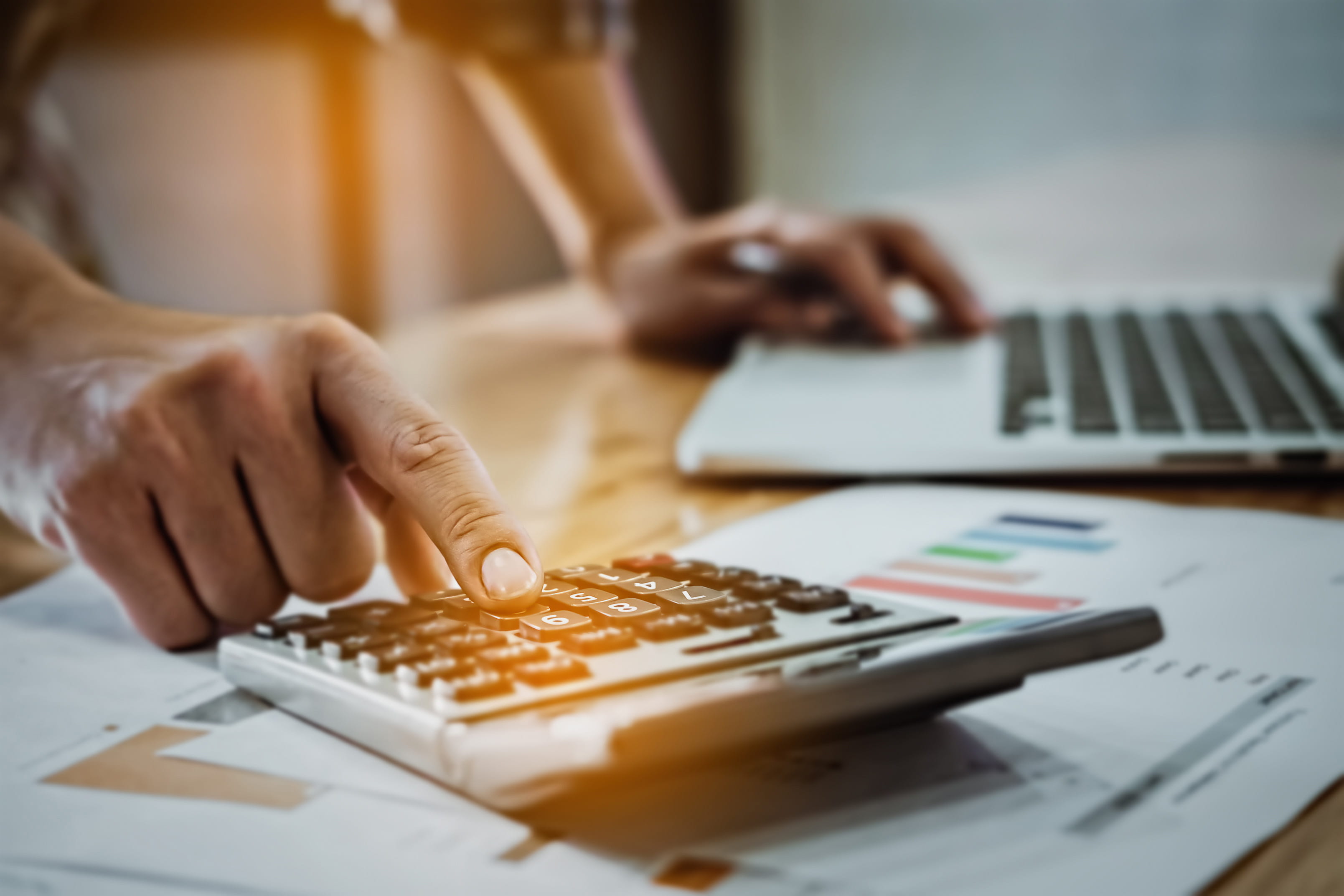 man looking at analytics data and using calculator 