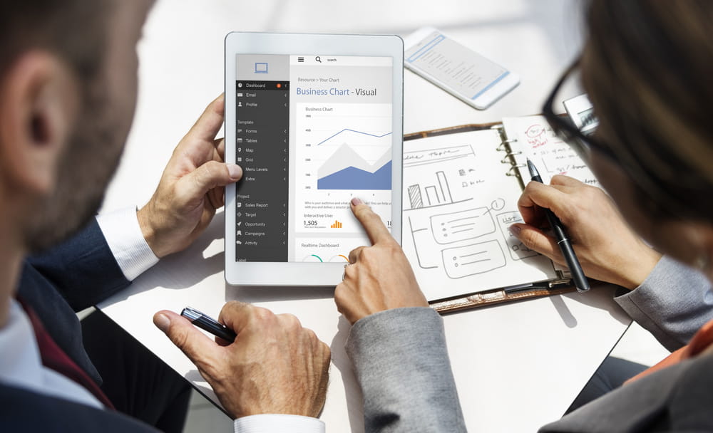 two people looking at a tablet with chart