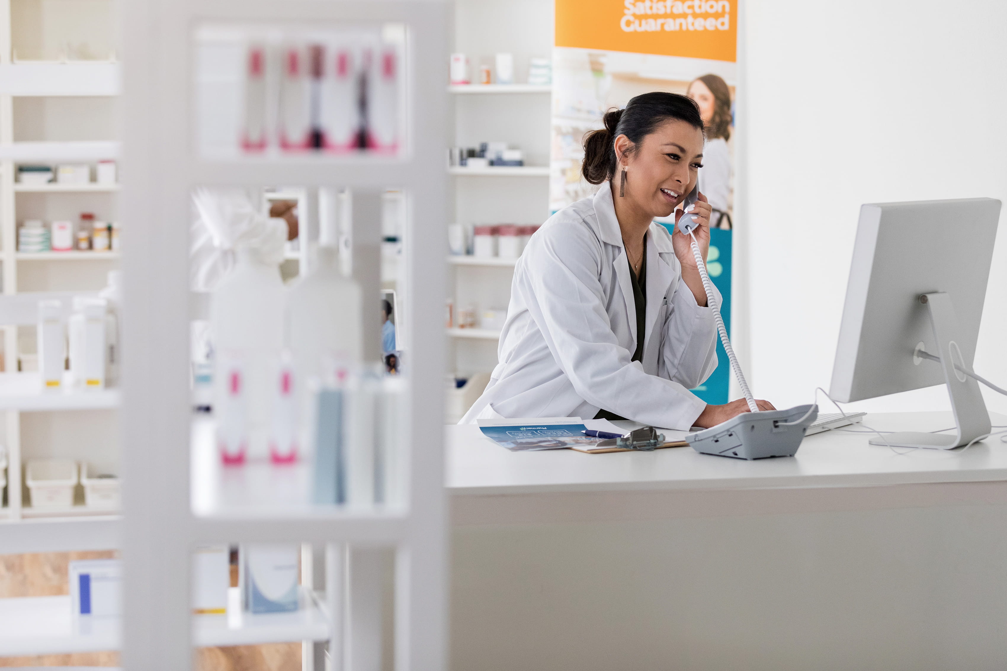 pharmacist on phone looking at monitor