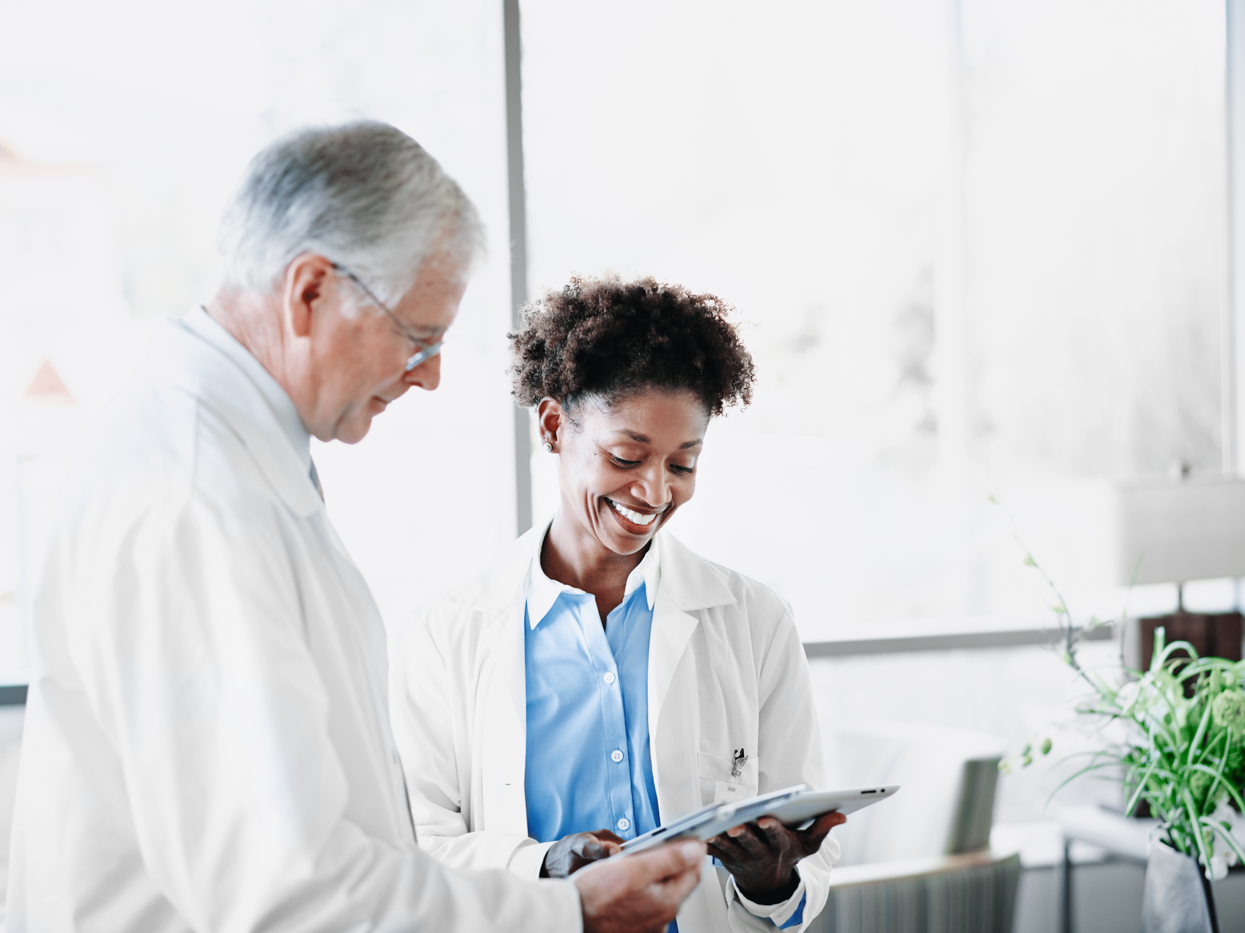 two doctors looking at digital information on tablet 